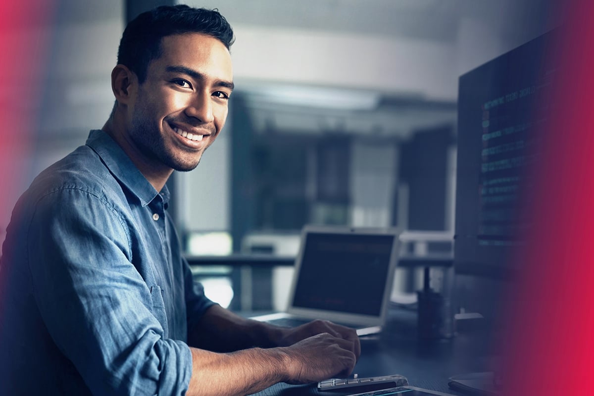 Smiling man typing on laptop