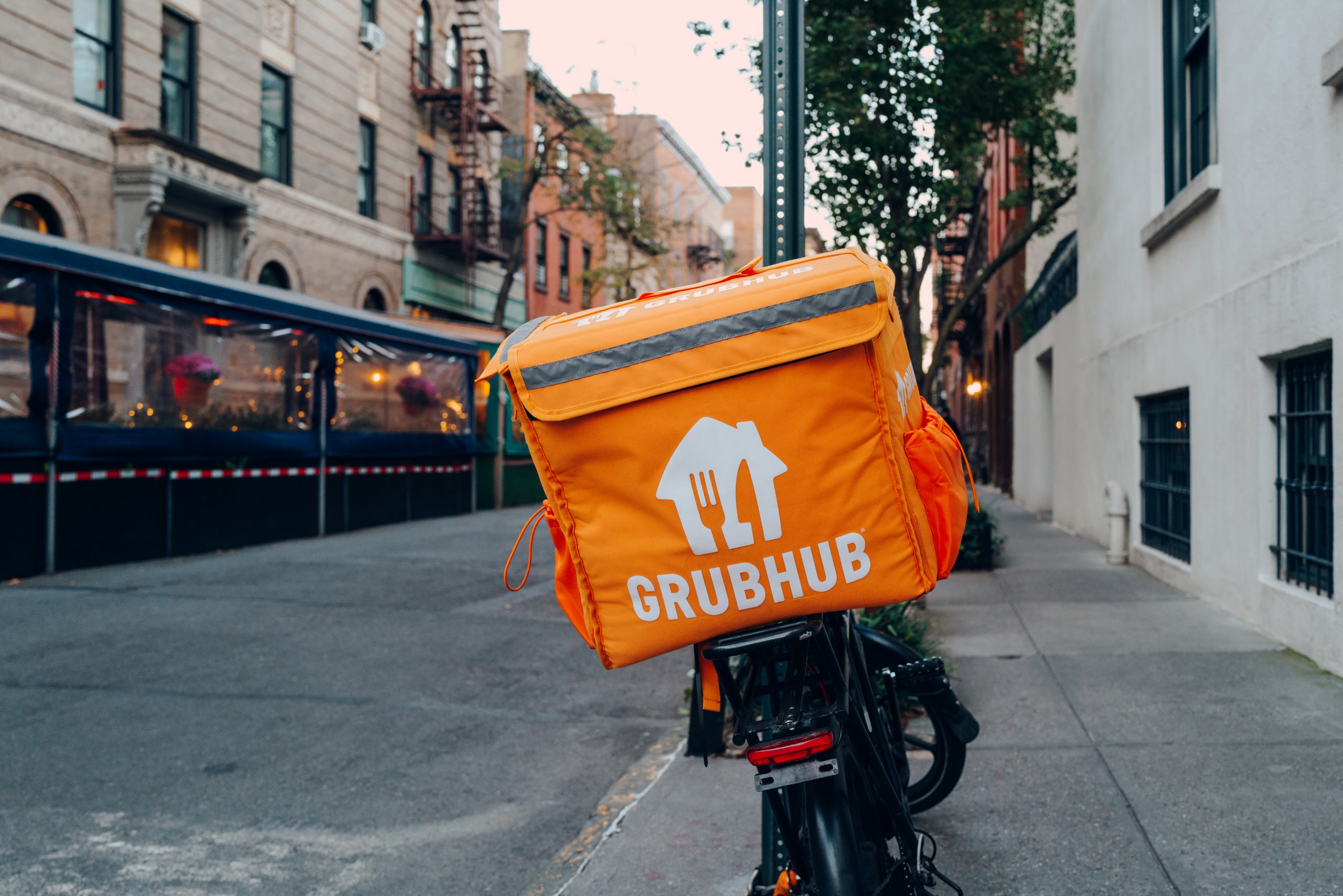 Grubhub bag on delivery bike with restaurant in peripherals