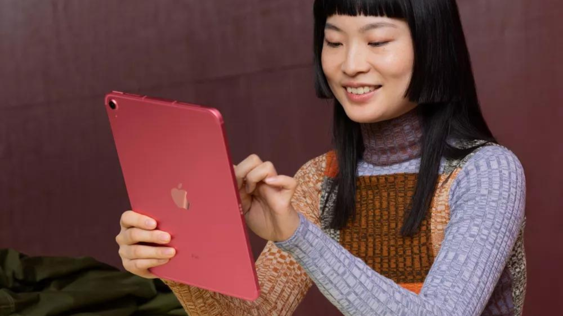 A person holding a pink iPad