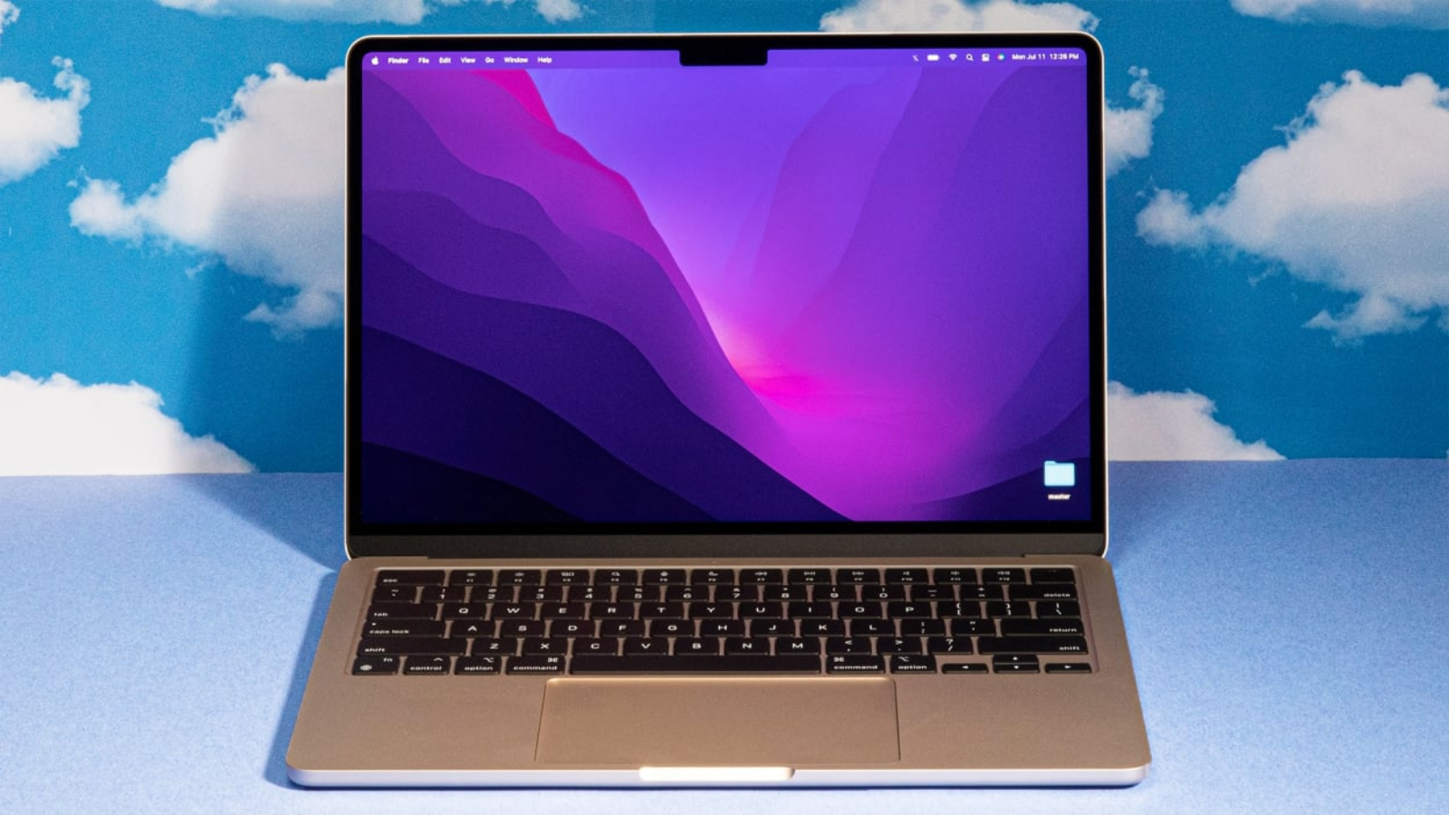 a 13-inch m2 apple macbook air against a cloud-patterned backdrop