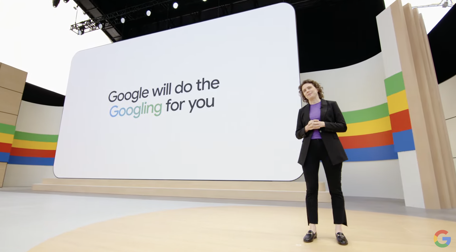 Google Head of Search Liz Reid in a black blazer stands in front of a giant screen