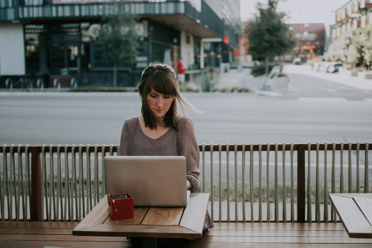 Woman working on laptop outdoors