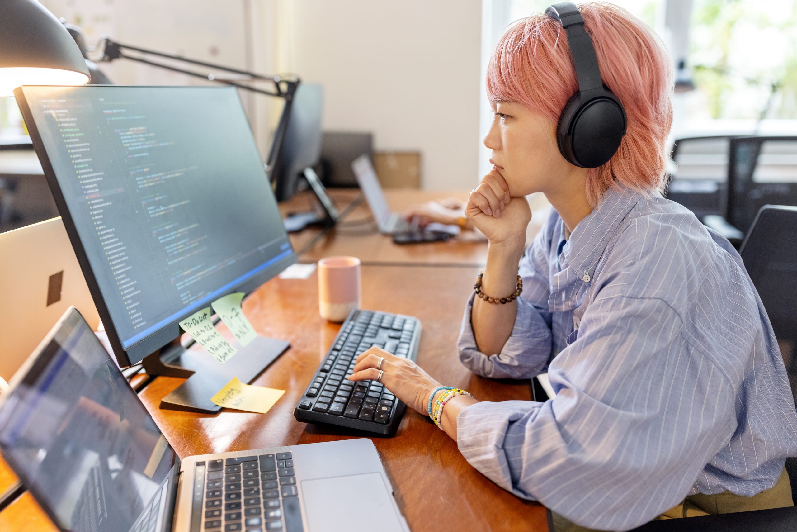 woman coding with headphones on