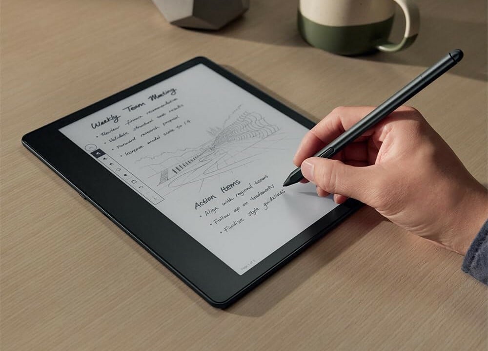 a person's right hand writes with the included basic pen on the Amazon kindle scribe