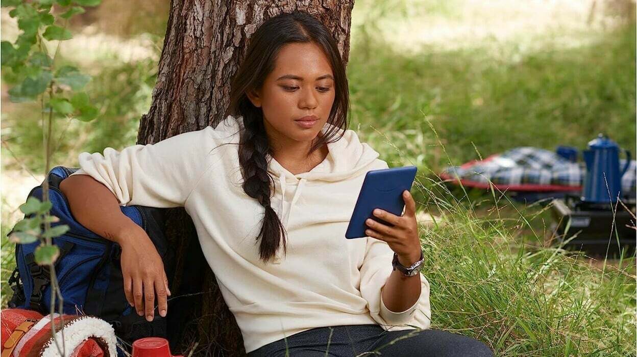 A woman reclines and reads an e-reader.