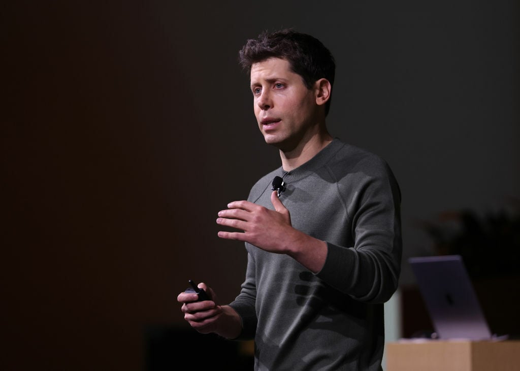 OpenAI CEO Sam Altman speaking onstage at the company's developer conference 