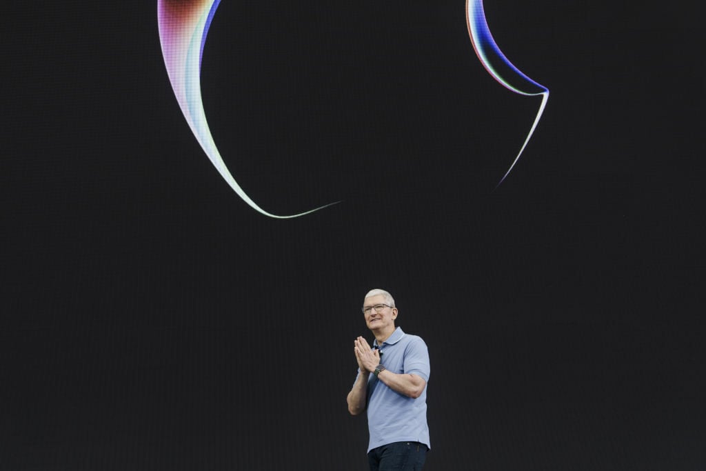 Apple CEO Tim Cook with his hands together on stage at WWDC 2023