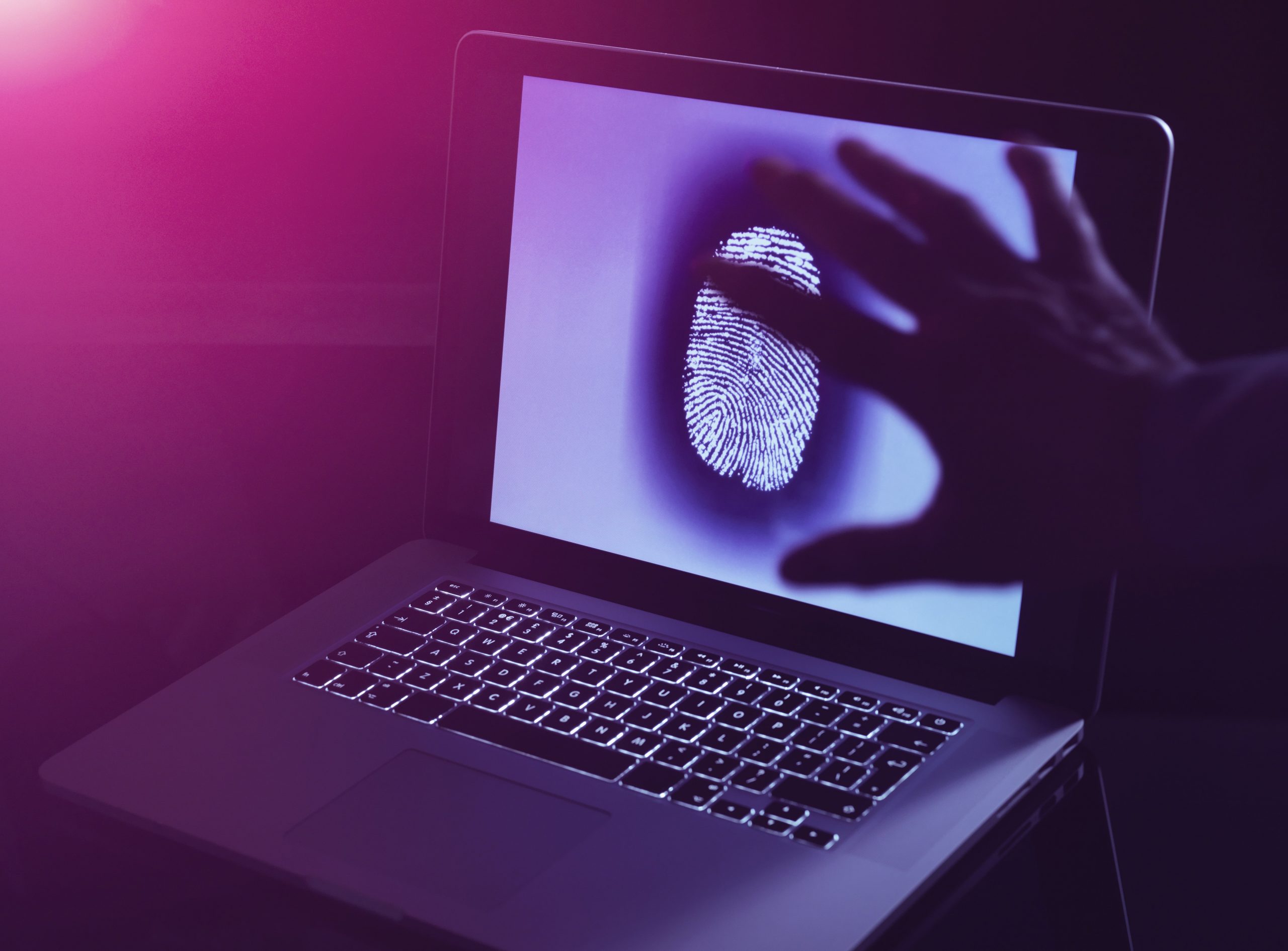 A laptop displaying a large fingerprint on its screen.