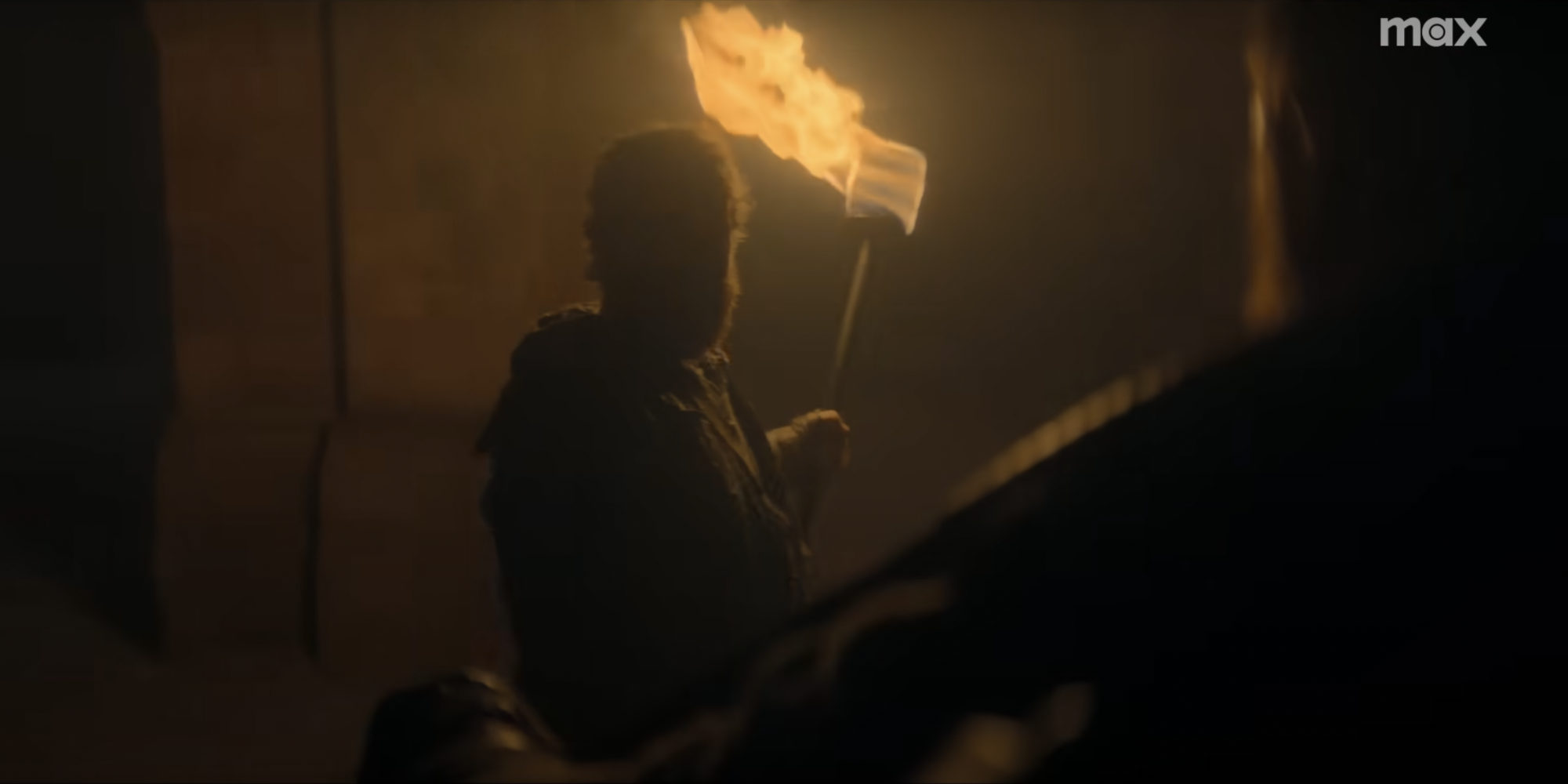 A shadowy man holding a torch.