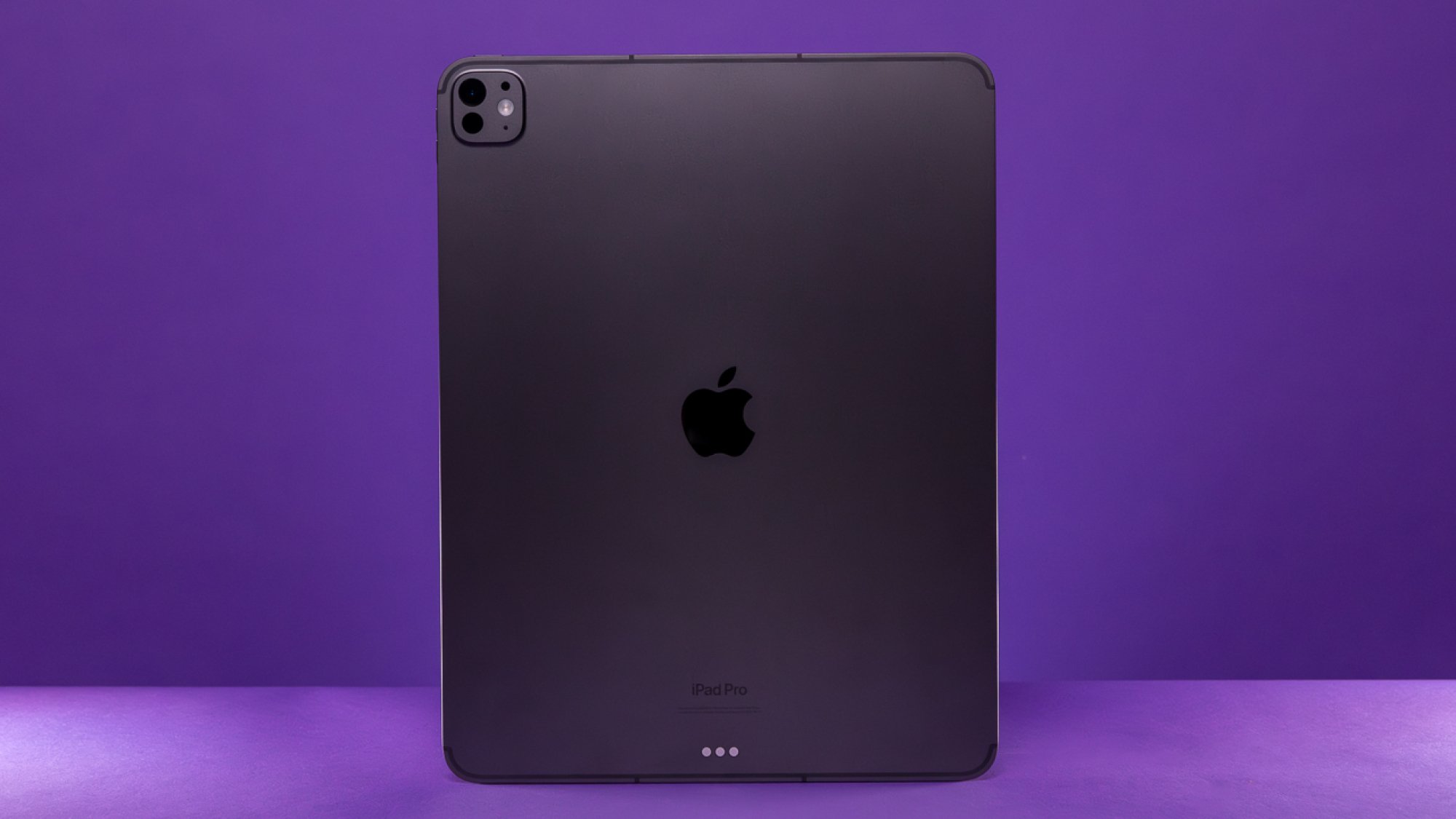 Back of the 13-inch Space Black iPad Pro against purple background