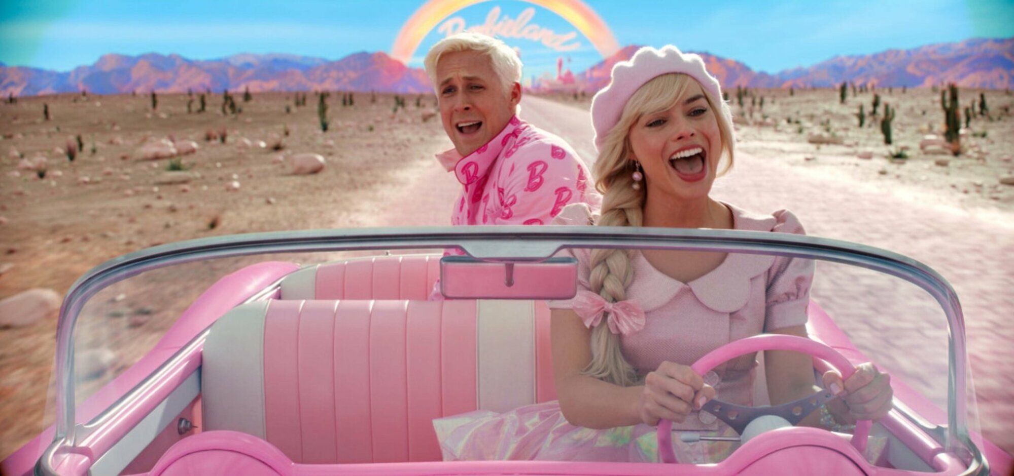 Barbie drives a car, singing, with Ken riding in the back.