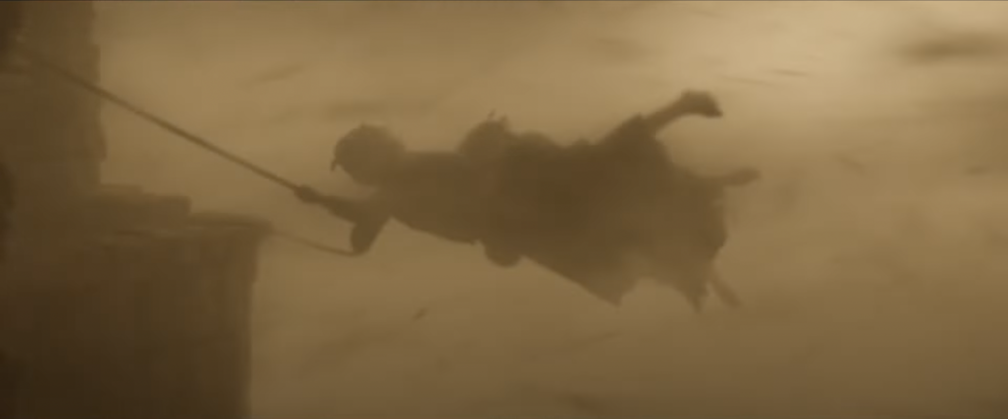 Markella Kavenagh as Nori Brandyfoot in "The Lord of the Rings: The Rings of Power," holding onto a rope during a massive sandstorm.