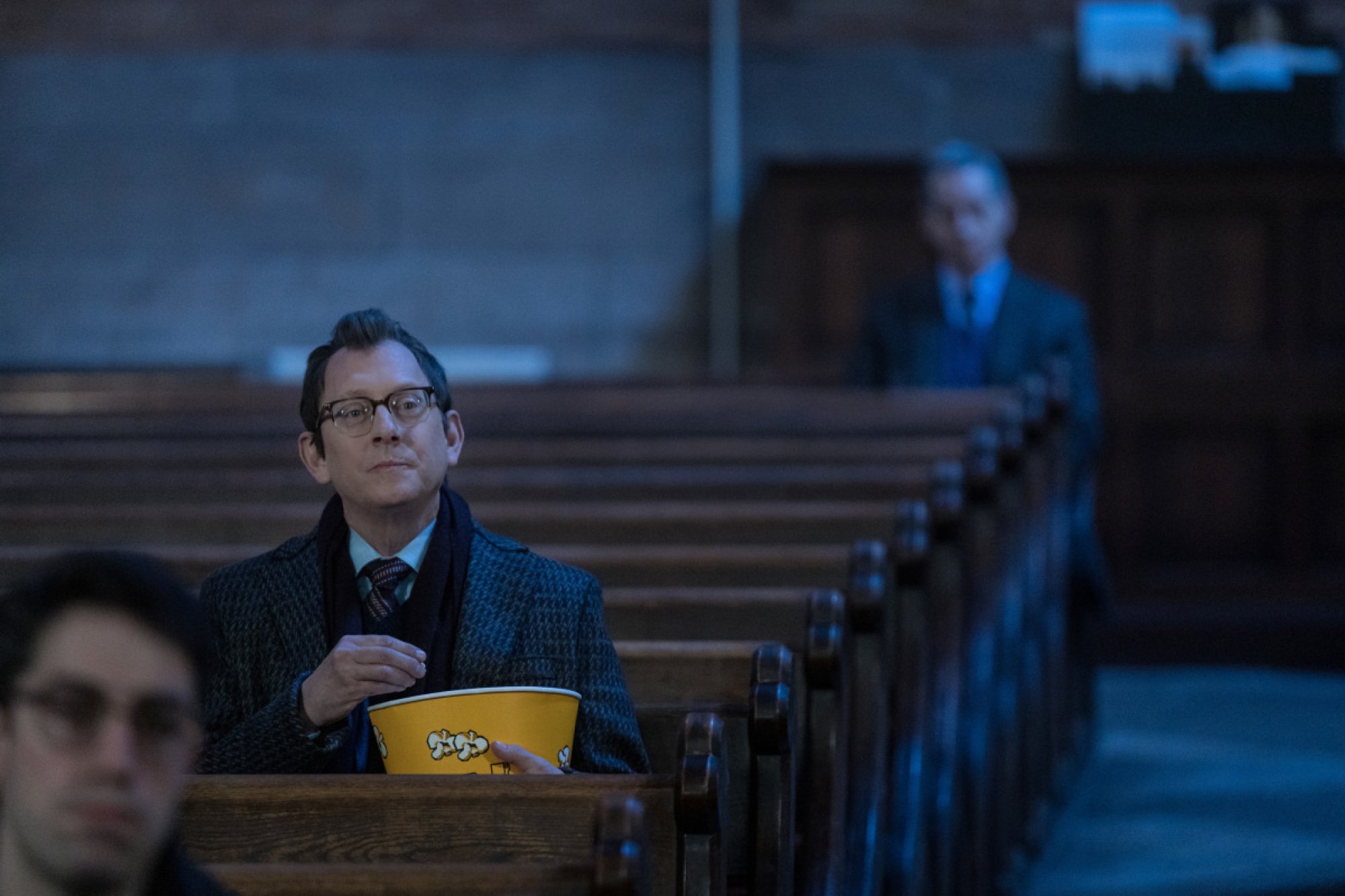 Michael Emerson eating popcorn in a church. 