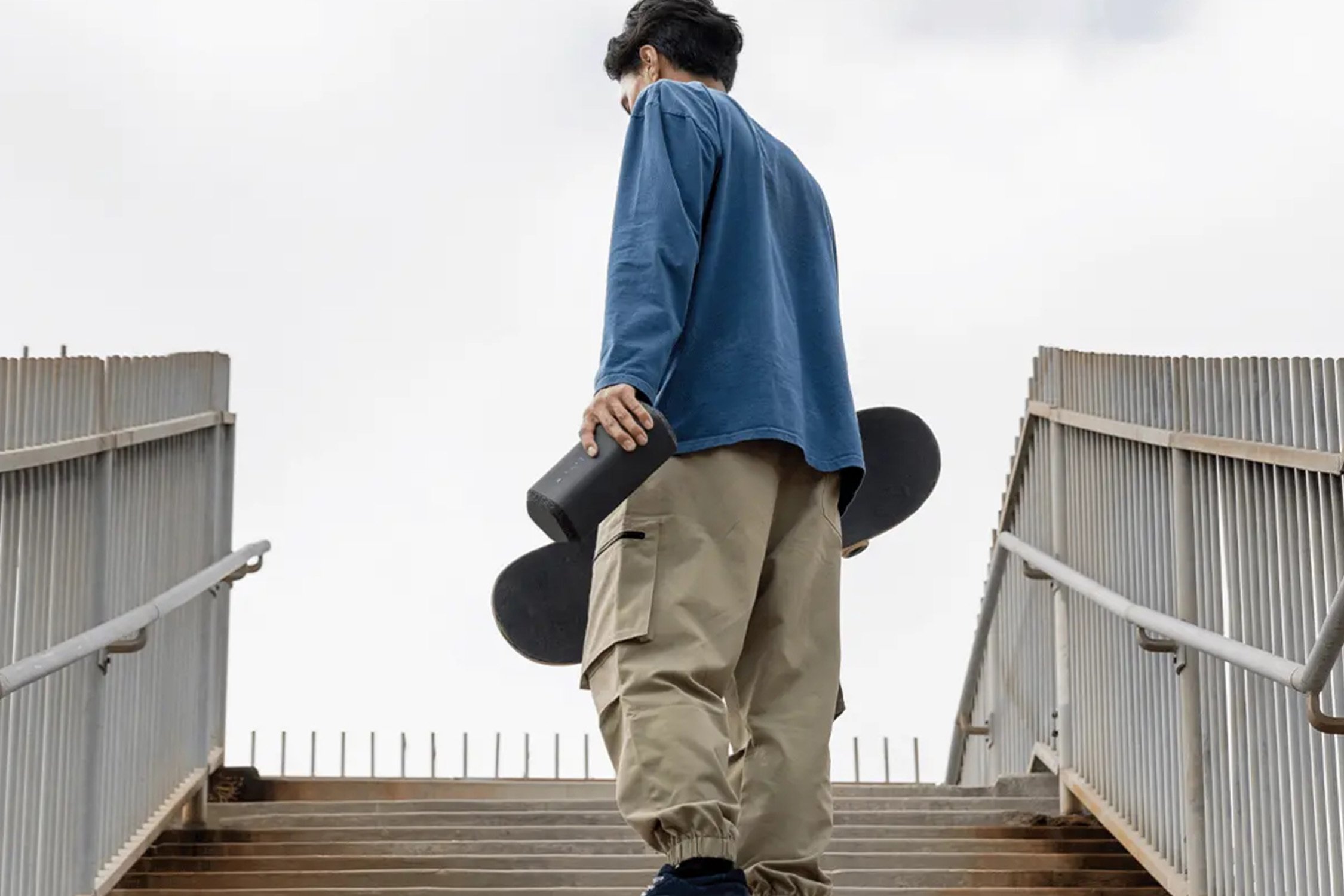 Man with sony speaker and skateboard.