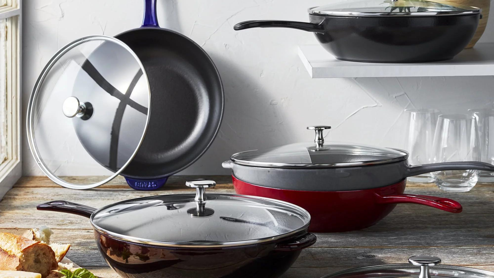 A collection of Staub cast iron pans in a kitchen.