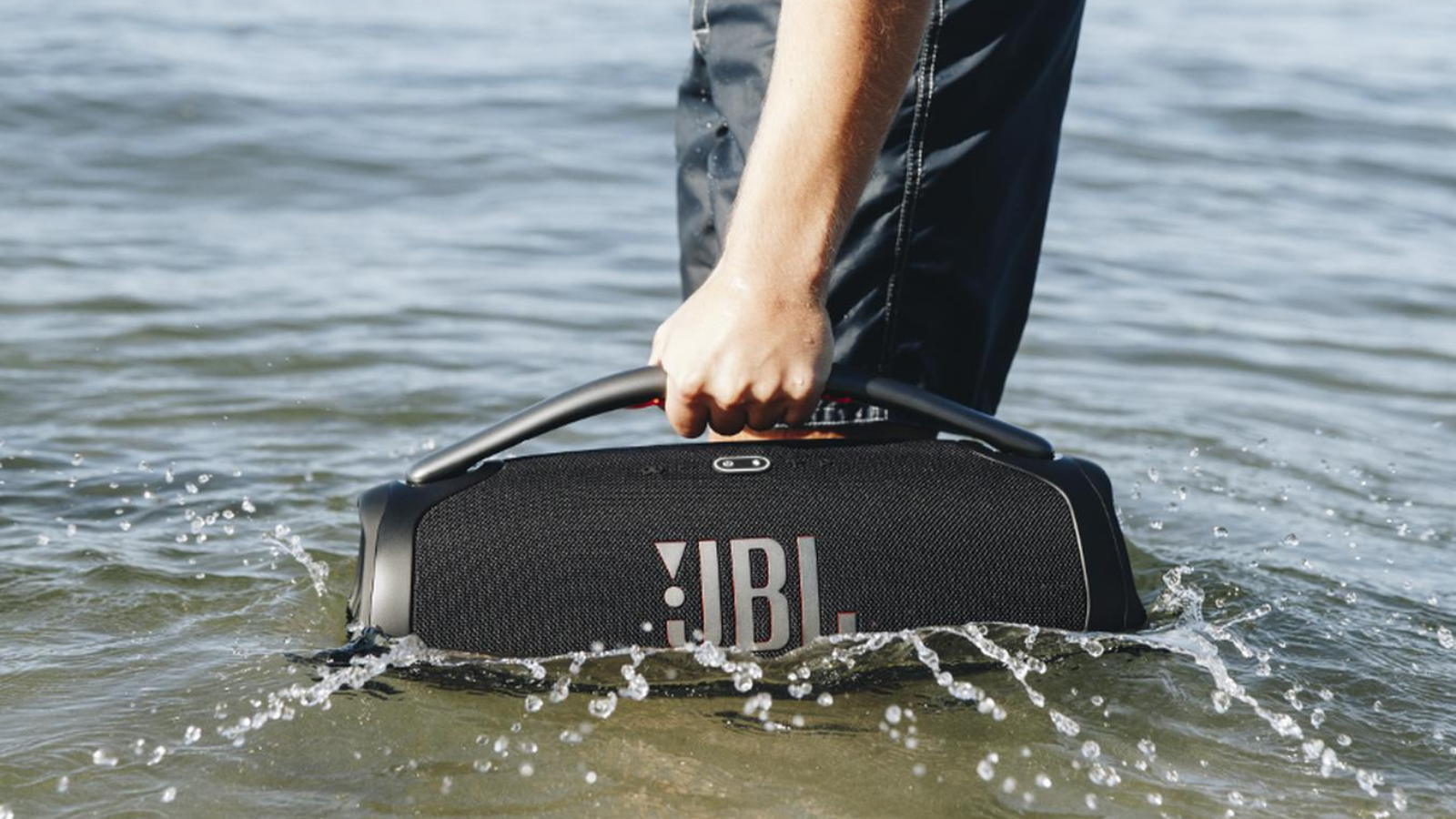 person holding JBL Boombox 3 in ocean