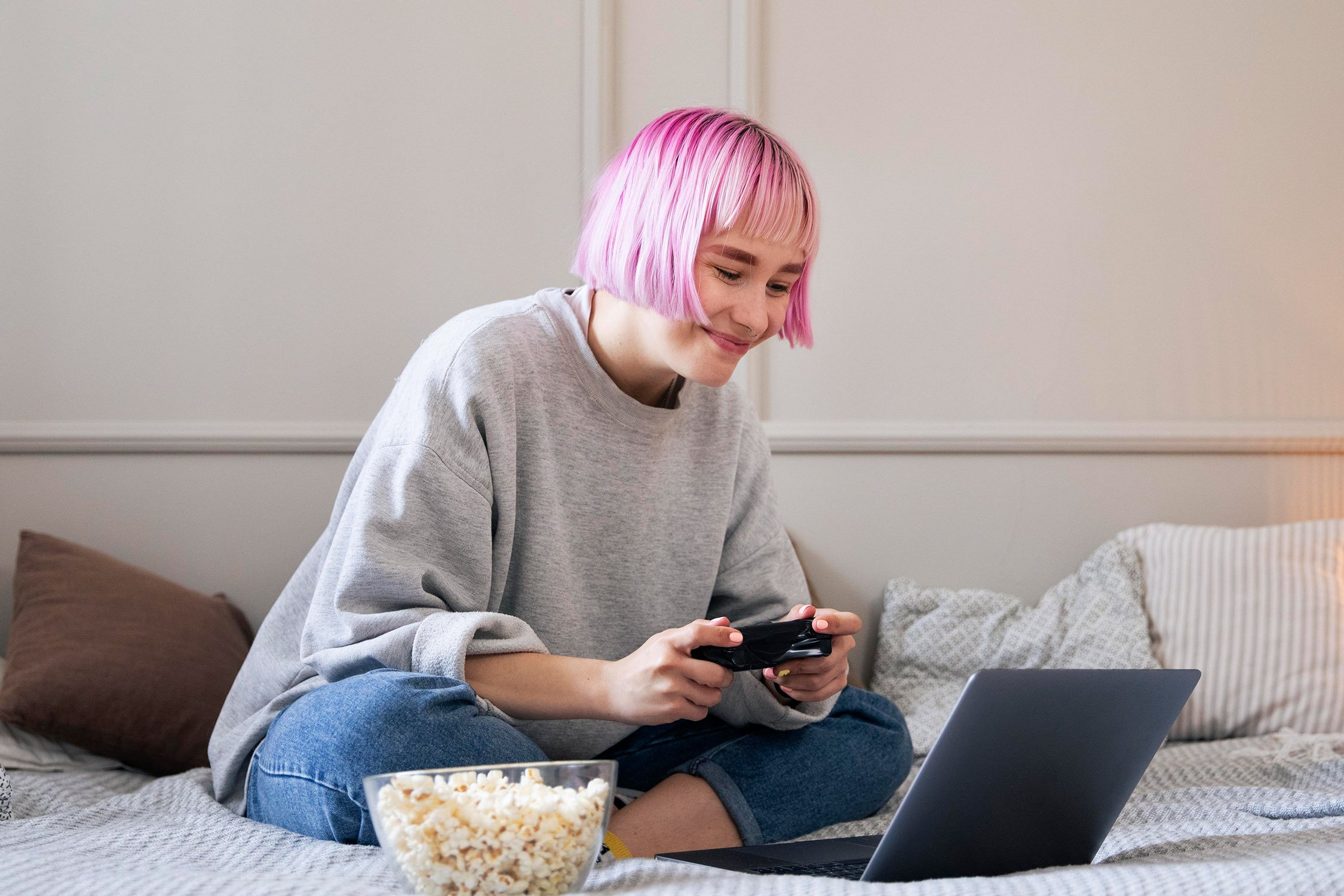 Woman with pink hair playing video games.