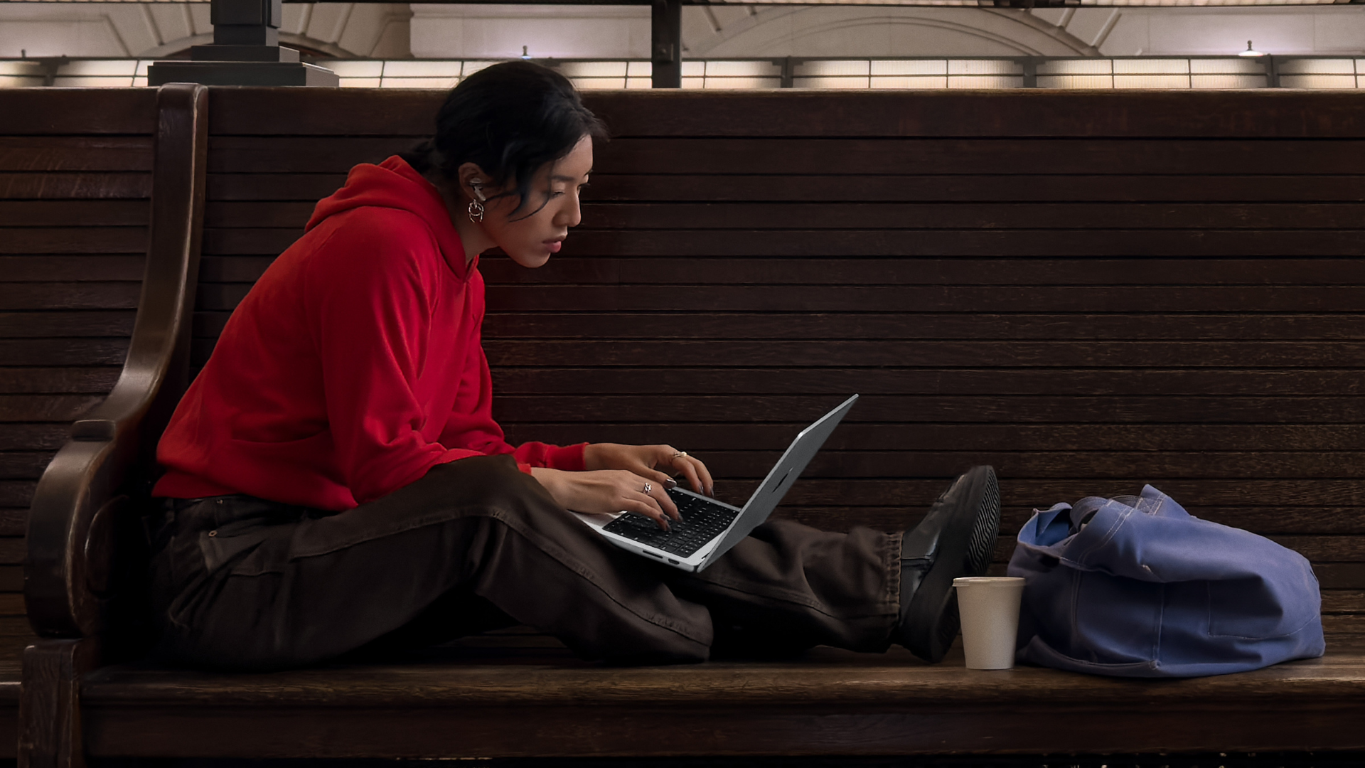 A person sitting on a bench using a MacBook Air