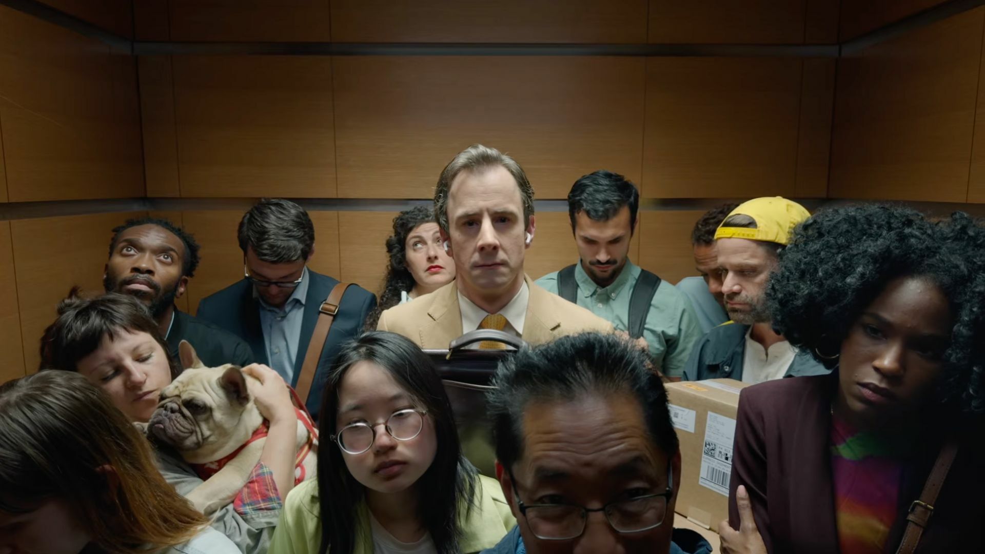 A man standing in a crowded elevator.