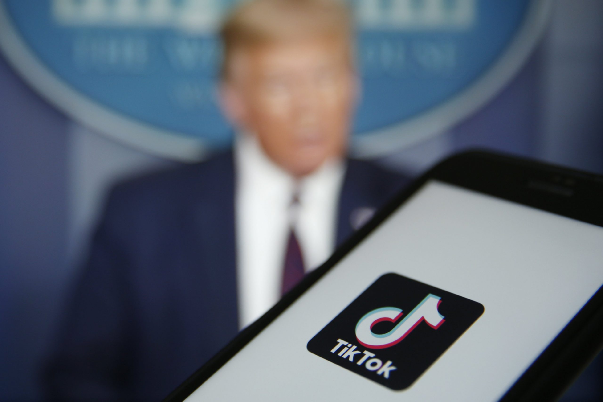 The TikTok logo is displayed in the app store in this arranged photograph in view of a video feed of U.S. President Donald Trump in London, U.K., on Monday, Aug. 3, 2020. TikTok has become a flash point among rising U.S.-China tensions in recent months as U.S. politicians raised concerns that parent company ByteDance Ltd. could be compelled to hand over American users data to Beijing or use the app to influence the 165 million Americans, and more than 2 billion users globally, who have downloaded it.