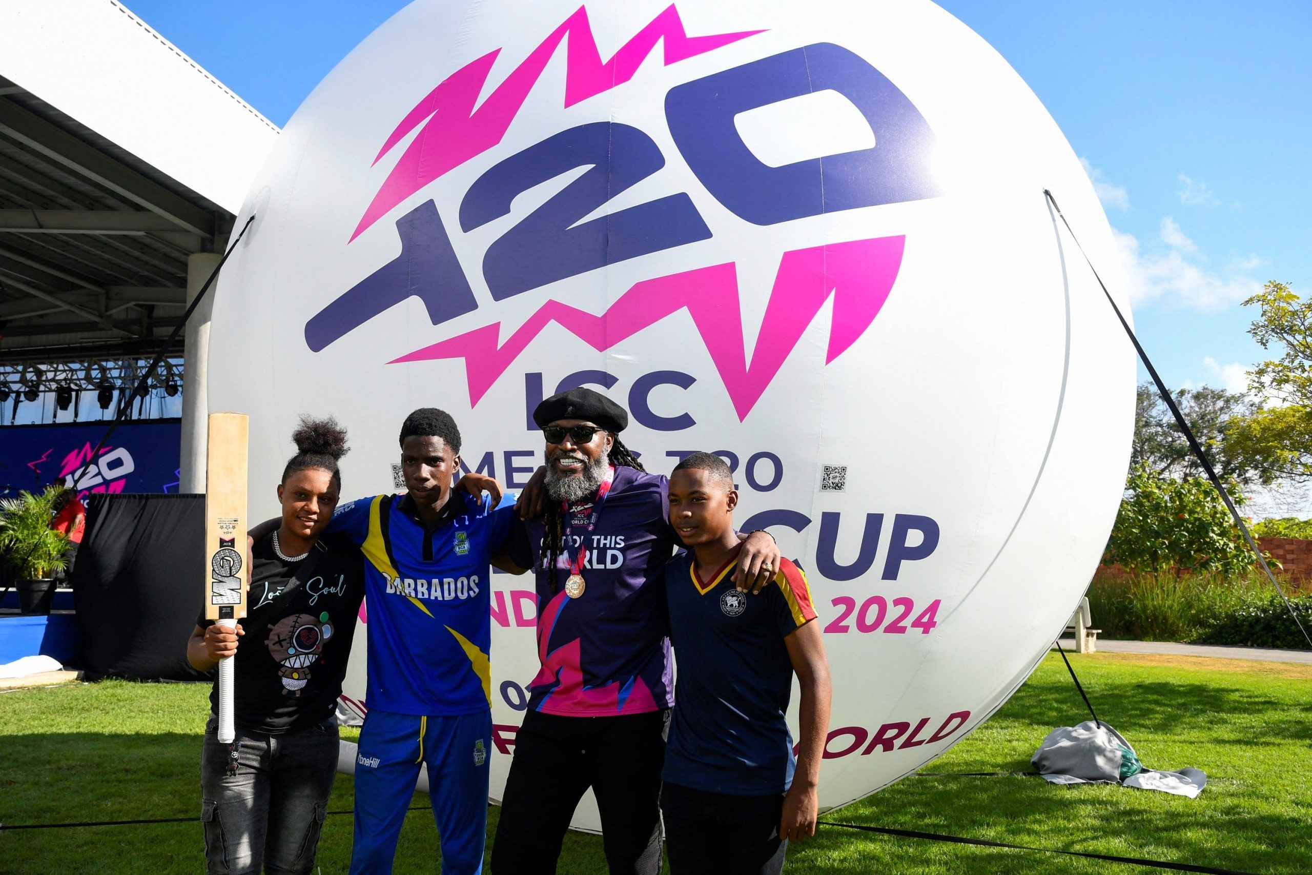 Chris Gayle of the West Indies poses with young Barbados cricketers