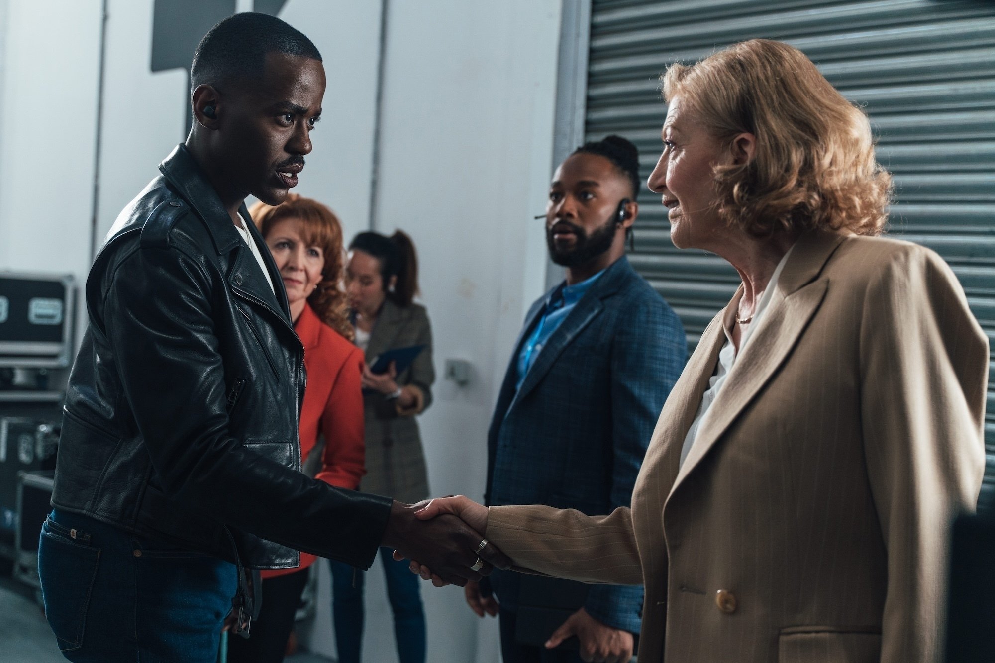 The Doctor shakes hands worriedly with a familiar woman in a business suit. 