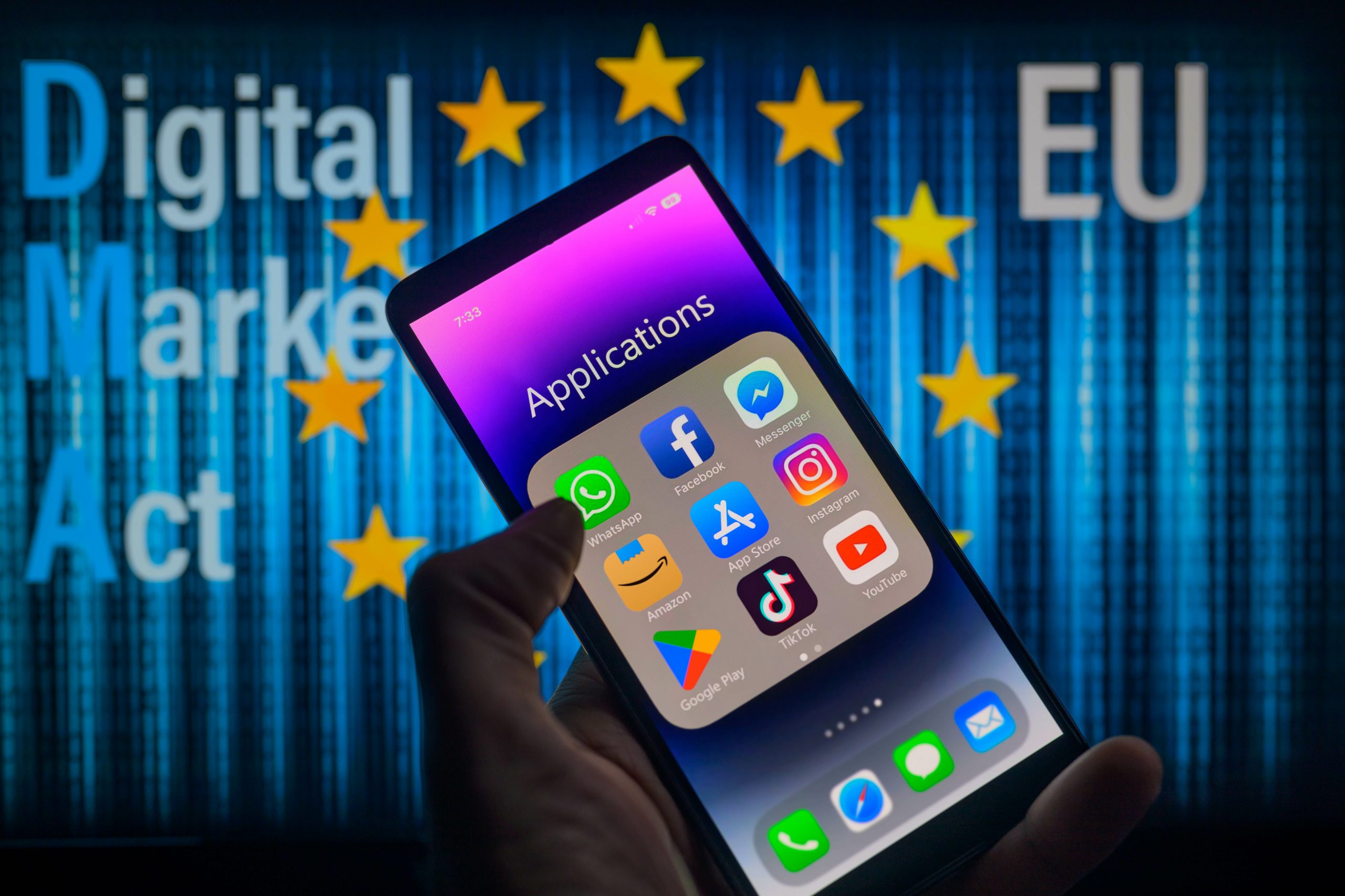 A phone displaying an applications folder in front of the European Union symbol. 