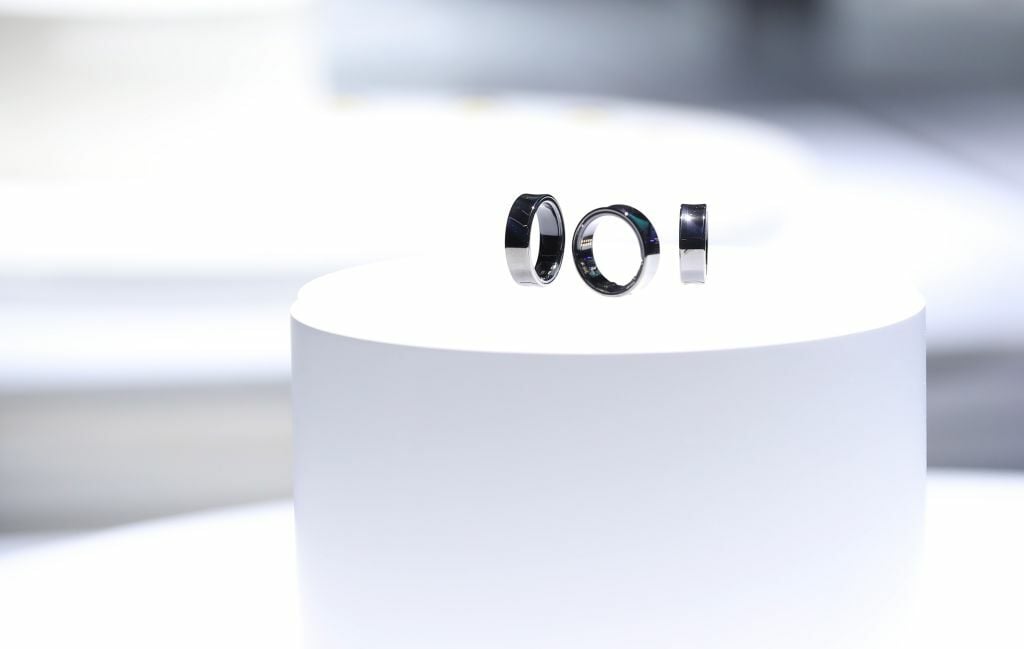 three platinum samsung galaxy rings on a white pedestal