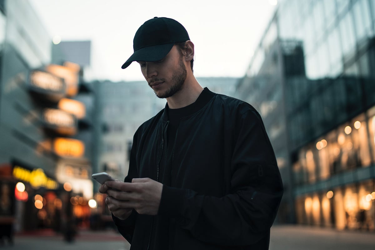 man in hat browsing their phone