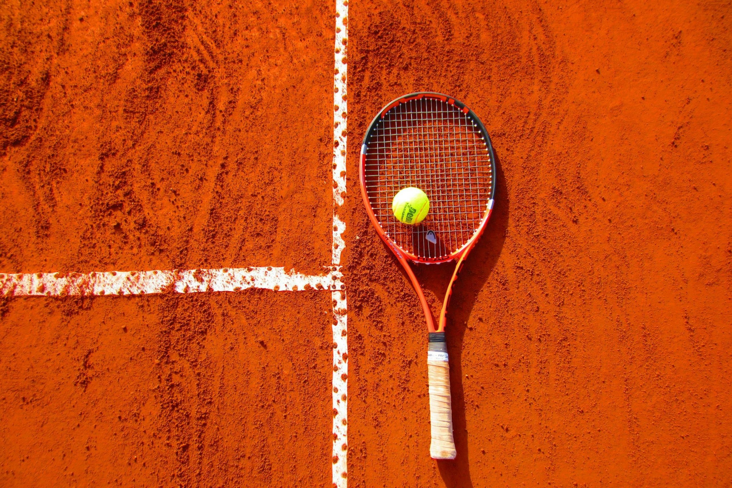 Tennis racket and ball on clay court