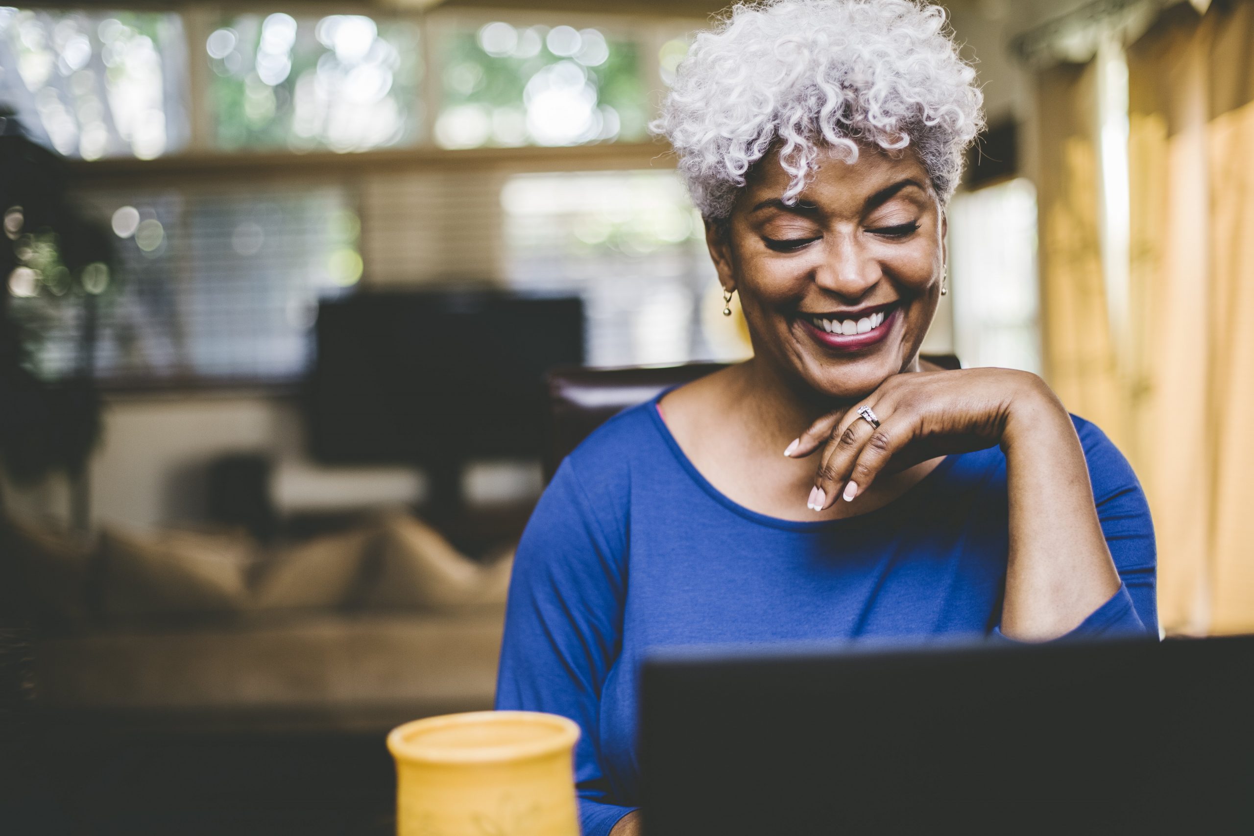 older woman using a laptop and smiling