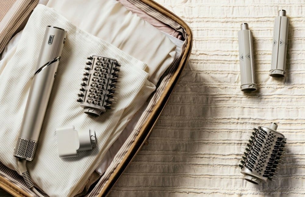 a sharkflex style hair dryer with accessories sits in an open suitcase