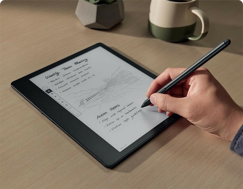 a right hand holds a pen over the kindle scribe