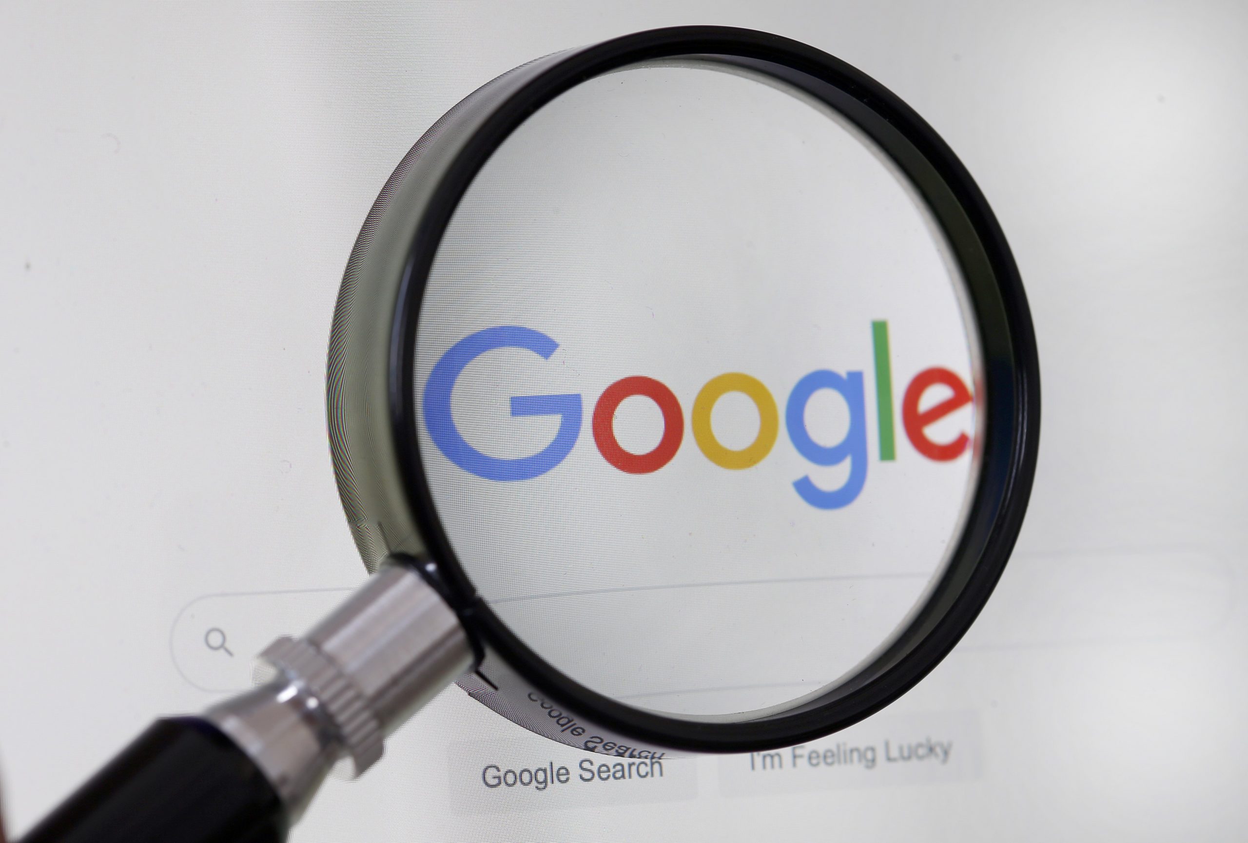 Google logo behind magnifying glass