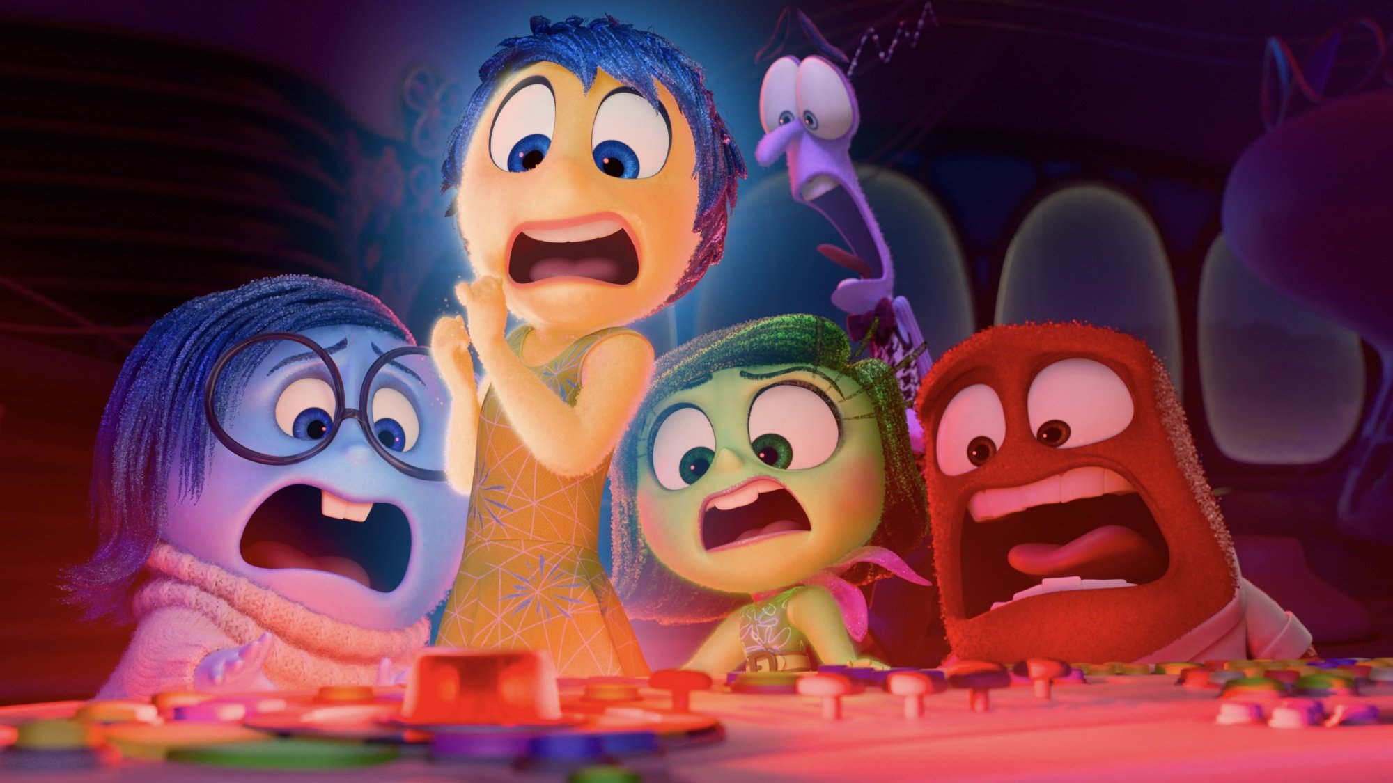 The emotions of "Inside Out 2" scream as they look at a flashing red button on a control panel.