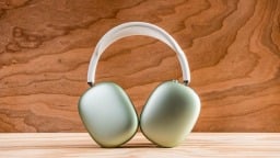 green airpods max against wooden background