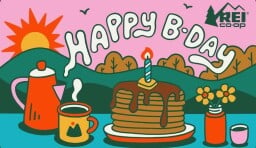 an REI gift card that says happy b-day with an outdoor scene and a stack of pancakes with a candle on top