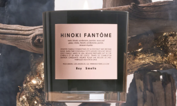 A Hinoki Fantôme candle against a woodsy background