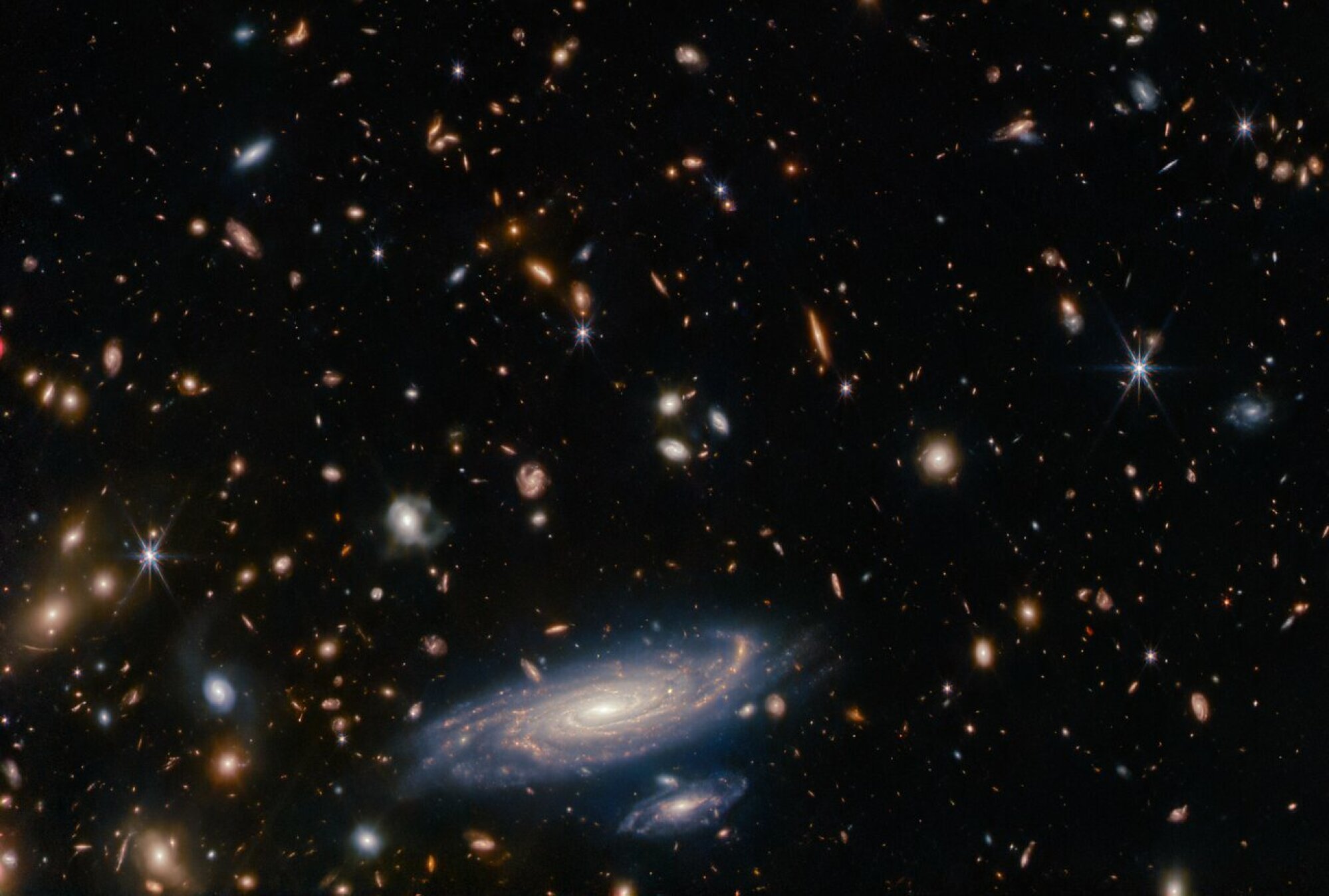 A deep view of the cosmos captured by the James Webb Space Telescope. Every object, except for the six-pointed foreground stars, is an entire galaxy.