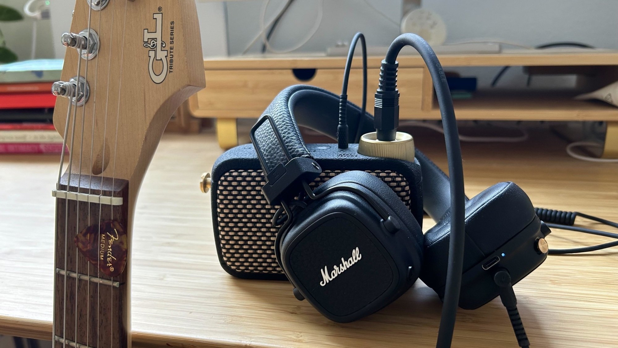 marshall headphones plugged into mini amp next to electric guitar