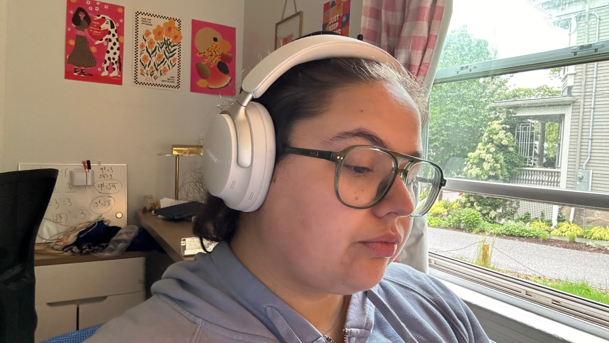 A person wearing glasses and the Bose QuietComfort Ultra headphones.