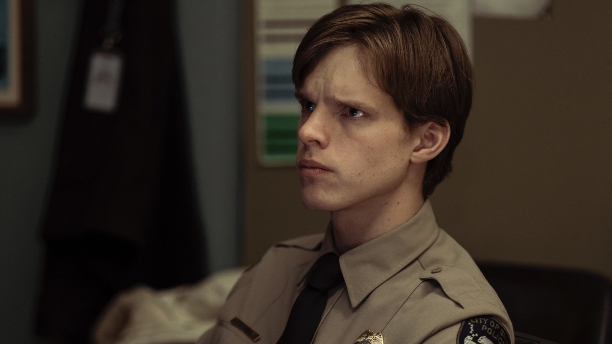 A young man in a tan police uniform.