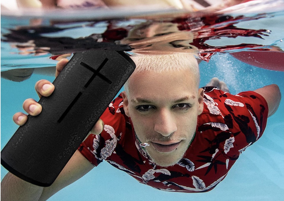 man holding a speaker under water