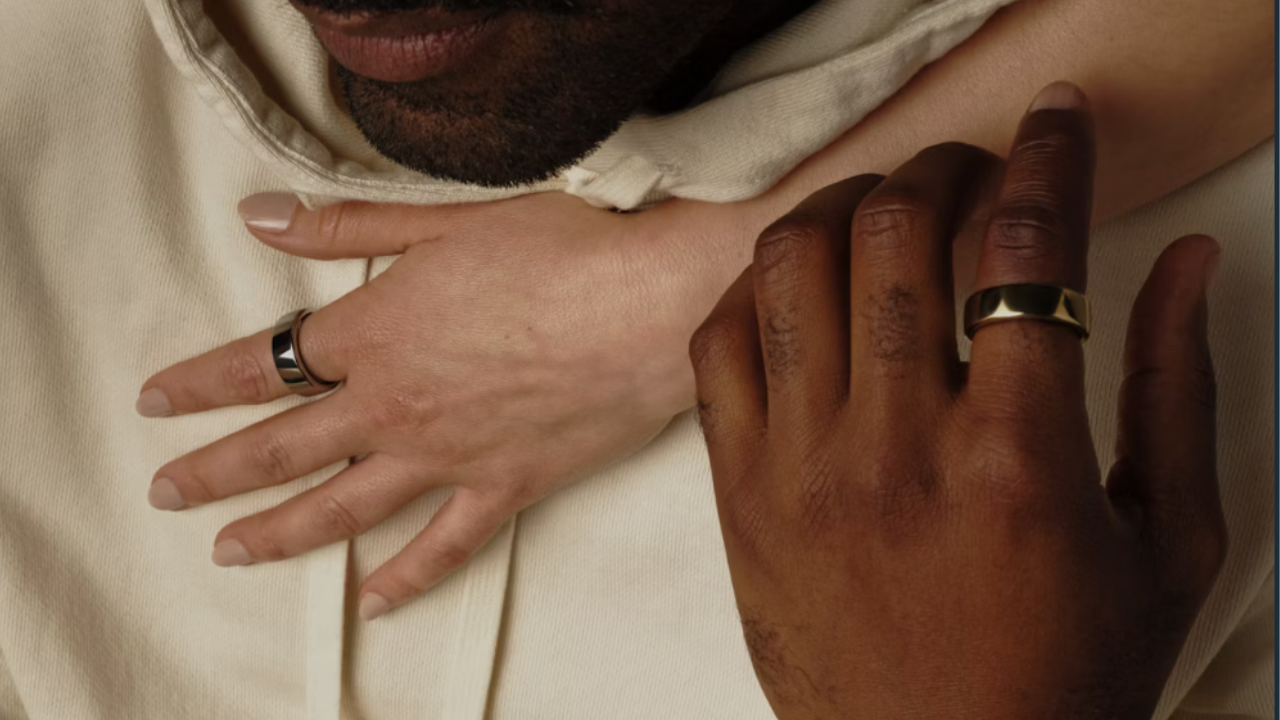 two people's hands with oura smart rings