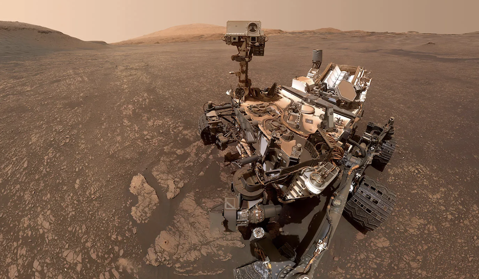 The dust-covered Curiosity rover exploring the Martian surface.