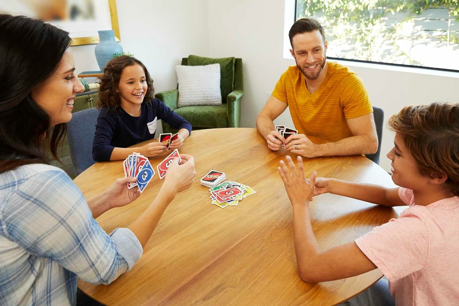 A family plays UNO around a table