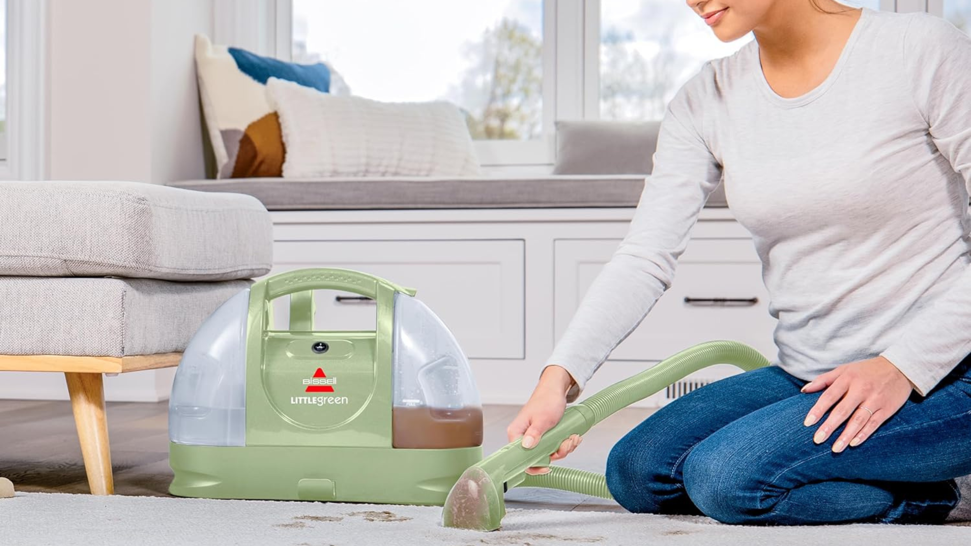 A person cleaning a carpet with the Bissell Little Green Machine