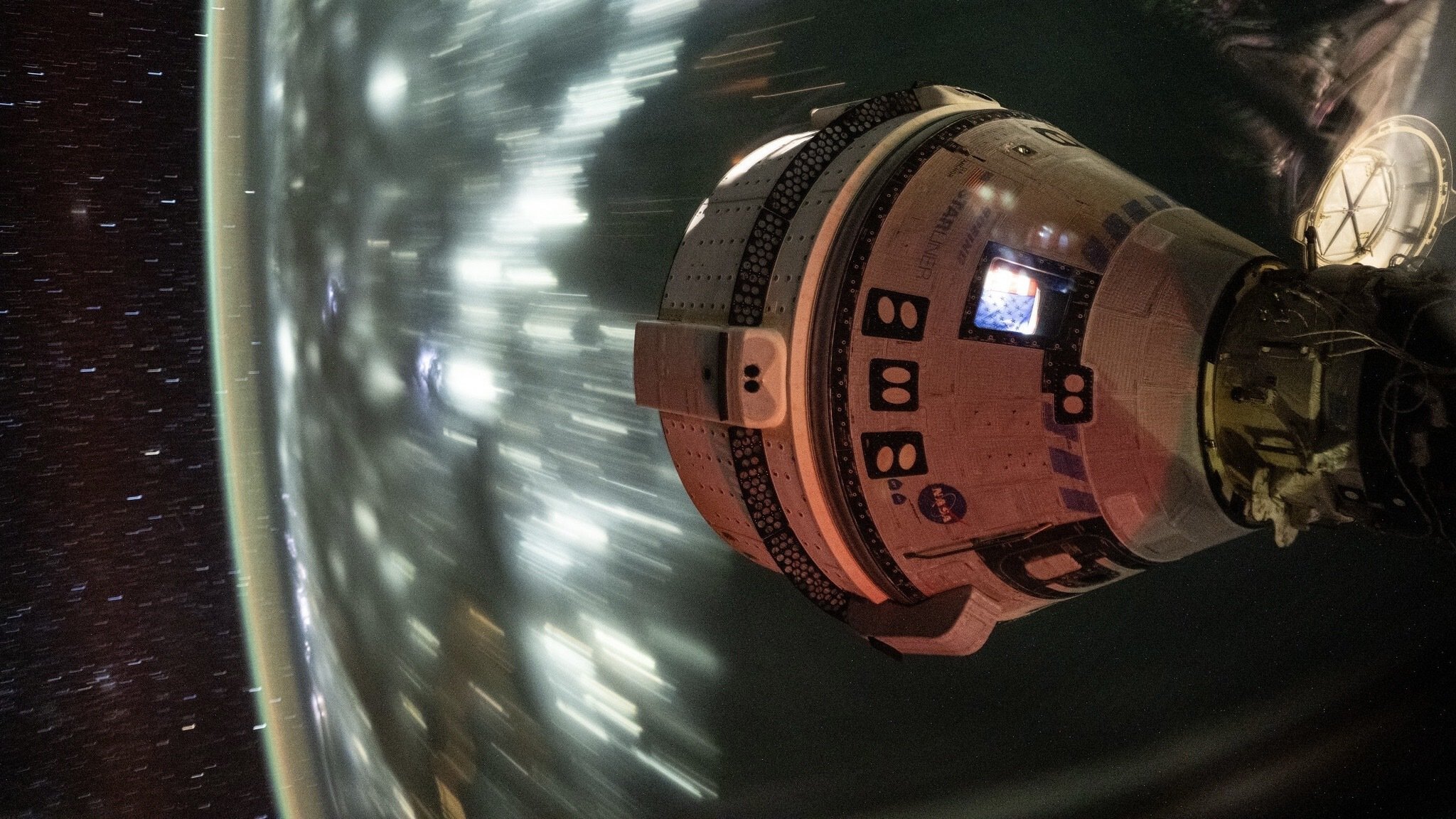 Boeing Starliner whizzing over Earth while docked at the International Space Station