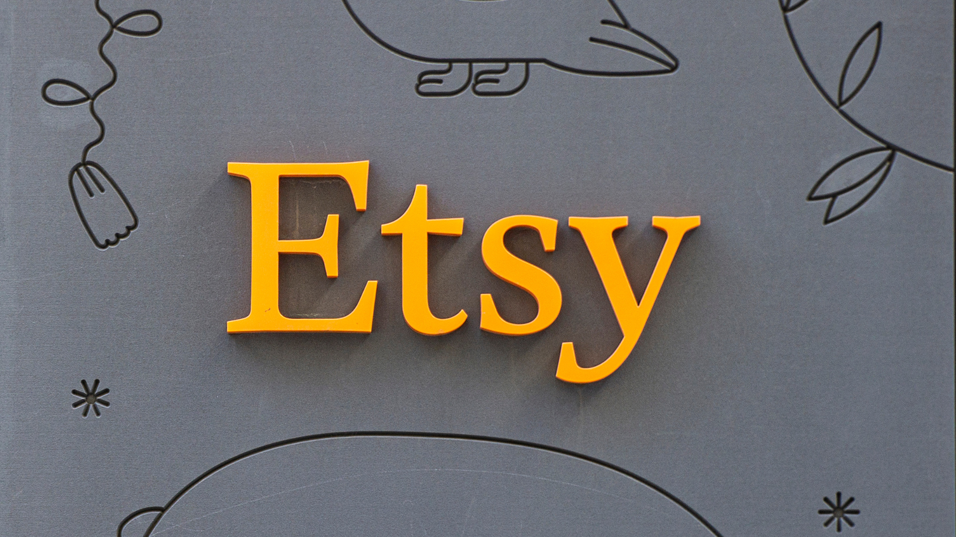 The Etsy logo in orange on a grey background.