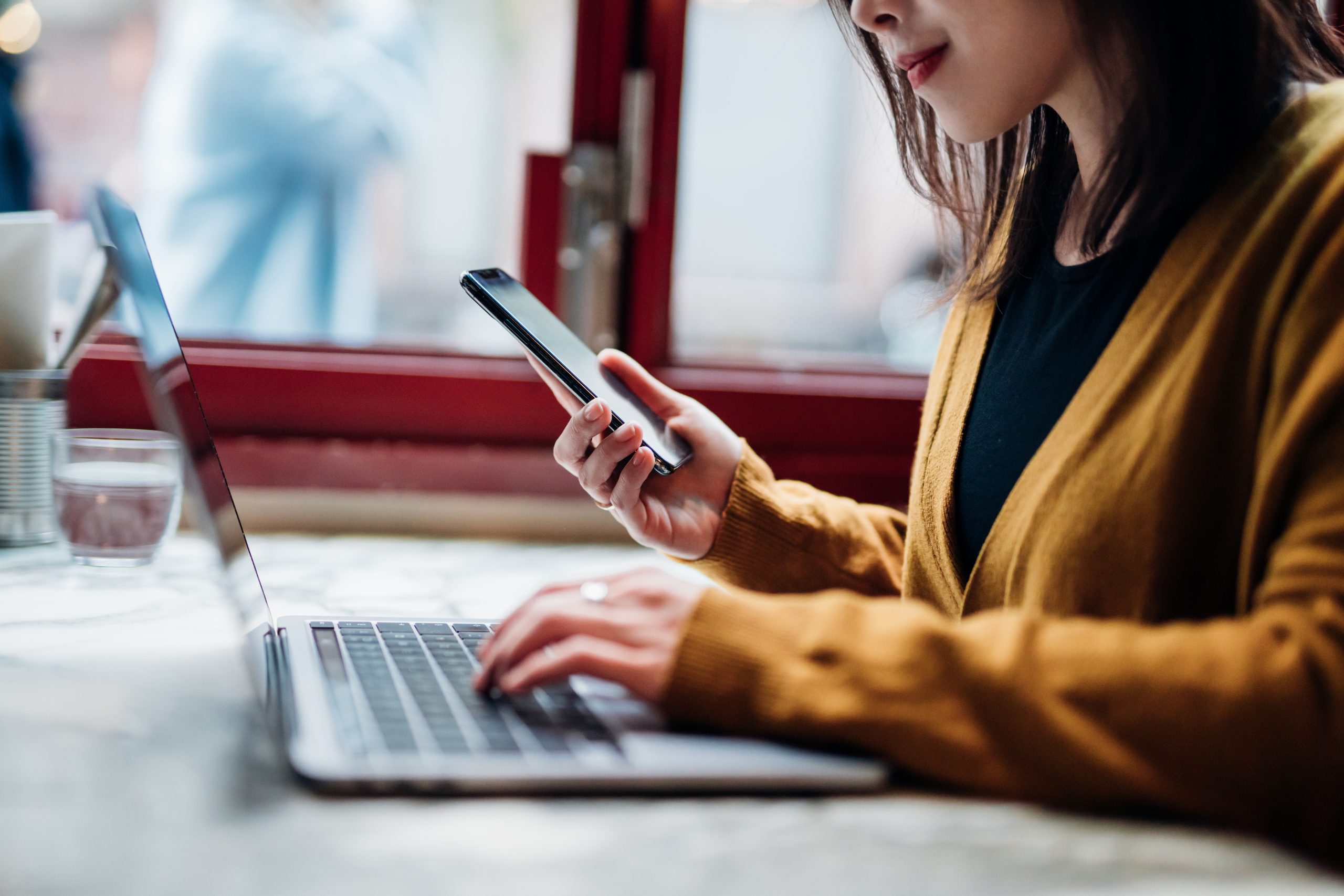 woman transferring data from phone to laptop